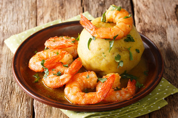 Latino american main course mofongo with shrimps and broth close-up on a plate. horizontal