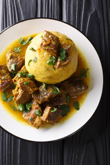 Traditional Mofongo with plantains, garlic and chicharron served with meat and broth close-up on a...