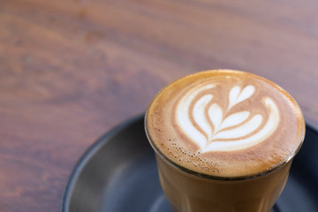 Coffee cup with latte art foam on wood table in coffee shop with copy space.Coffee is one of the most popular beverages.Improve Energy Levels and Burn Fat