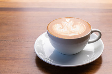 Coffee cup with latte art foam on wood table in coffee shop with copy space.Coffee is one of the most popular beverages.Improve Energy Levels and Burn Fat