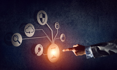 Close of businessman hand showing at user interface glowing on wall