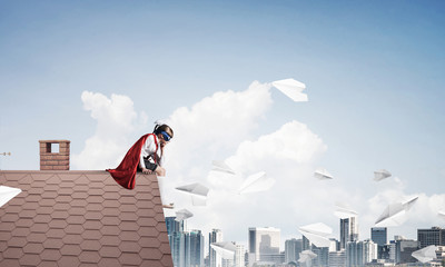 Girl power concept with cute kid guardian against cityscape background. Mixed media