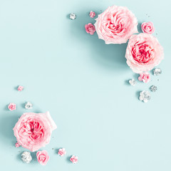 Flowers composition. Frame made of rose flowers on pastel blue background. Valentines day, mothers day, womens day, spring concept. Flat lay, top view, copy space, square