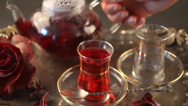 pouring hibiscus (karkade) tea into transparent cups