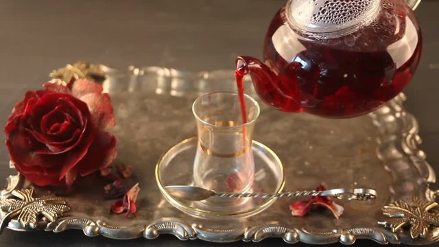 pouring hibiscus (karkade) tea into transparent cups