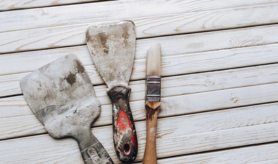Kit of putty knives. Spatulas with the remaining mortar. Gastarbeiter or guest worker concept....