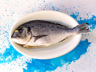 Raw dorada fish, ready for cooking, overhead view