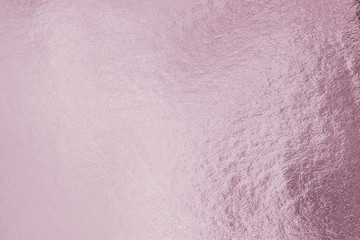 Rose gold pink purple color shiny paper foil leaf texture background with bright brilliant reflective glossy metallic material surface.