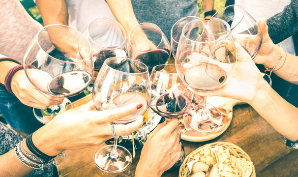 Friend hands toasting red wine while having fun outside cheering with winetasting - Young people enjoying  drinks on harvest time together at farmhouse vineyard countryside - Youth friendship concept