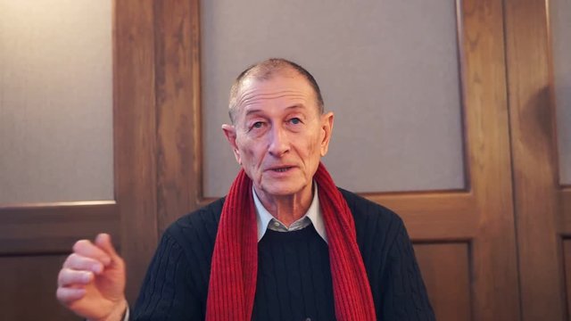 Businessman presentating business company. Senior man speaks to camera.