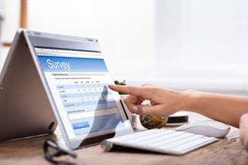 Businesswoman's Hand Filling The Survey Form On Laptop