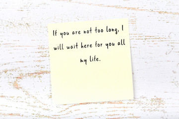 Positive inspiring quote handwritten on sticky note on wooden background