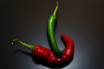 Hot Chilli Peppers red and green isolated by black background. Food Concept and beverage