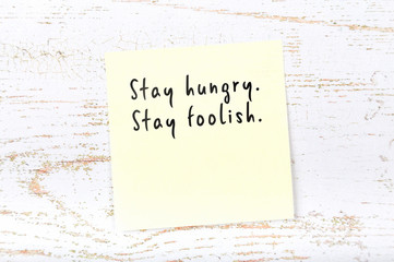 Positive inspiring quote handwritten on sticky note on wooden background