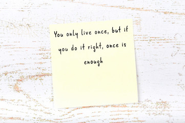 Positive inspiring quote handwritten on sticky note on wooden background