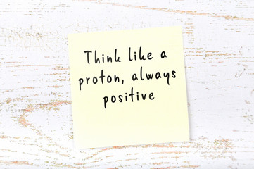 Positive inspiring quote handwritten on sticky note on wooden background