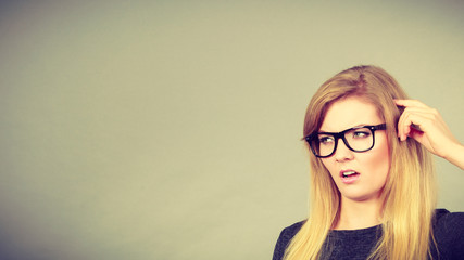 Nerdy woman in eyeglasses being confused