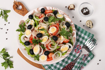 Healthy salad of organic lettuce with canned tuna, tomatoes, quail eggs, black olives and white onions 
