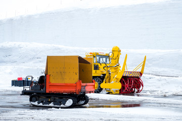 Snow removal truck in Japan, two trucks for snow vehicle for removal ,plow ,clear snow in walking wall ,Tateyama Kurobe Alpine Route Japan Mountain Alps in Japan, Japanese snow removal yellow truck. 