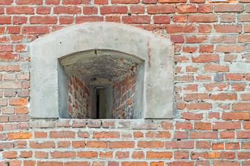 loophole in the wall of the old fortress. a loophole in a thick brick wall in a historic building. Window loophole in the old castle 