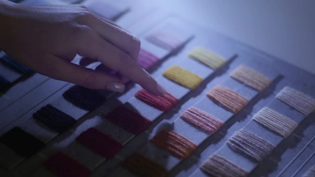 Shot of a person choosing from a color palette. The theme is textile/fashion, and the shot has a tilt camera movement.