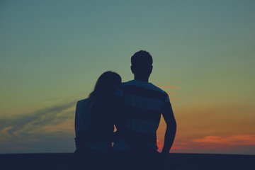 Fototapeta na wymiar Silhouettes of a couple in sunset / sunrise time.