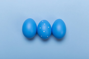 Colorful easter eggs in nest on pastel color background with space.