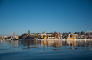 Fototapeta na wymiar A cold winter morning in Stockholm with snow and ice on islands and boats