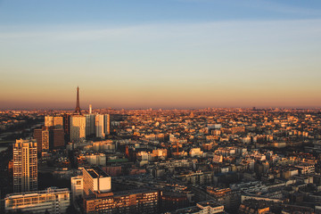 Obraz premium Eiffel tower between buildings in the last rays of the sun. Aerial view of Paris, France