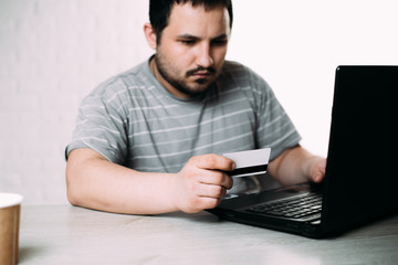 Cropped picture of man with credit card white pattern and phone
