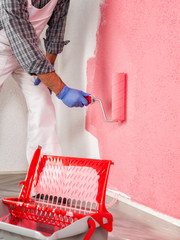 Professional house painter at work painting the wall © francescomou