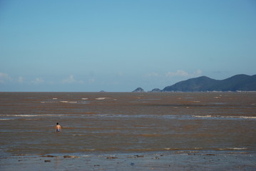 Seaside, dirty sea, blue sky, coast the view from the beach low water