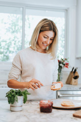 Woman spreading vegan cream cheese on a toast