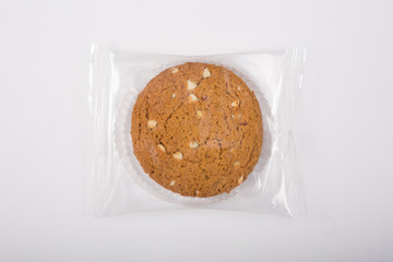 Oatmeal cookie in a plastic pack on a white