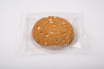 Oatmeal cookie in a plastic pack on a white