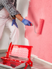 Professional house painter at work painting the wall © francescomou