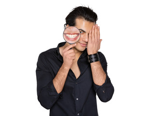 the man smiles and shyly closes his eyes with his hand in his hands a magnifying glass with a...