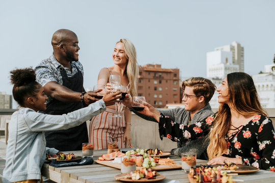 Cheerful friends toasting at a rooftop party