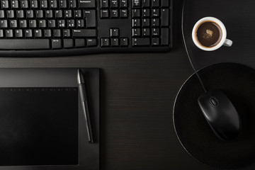 Total black desk with pc, tablet and cup of coffee