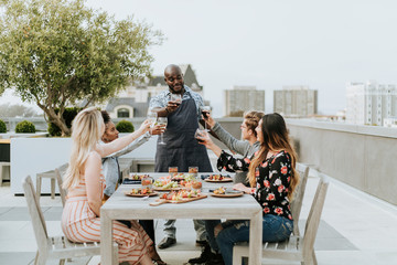 Friends toasting with the chef at a summer party