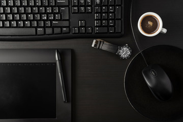 Total black desk with pc, tablet and cup of coffee