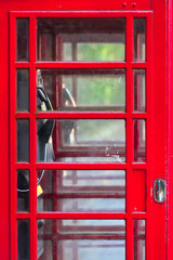 Telephone Booth Door Close Up / Detail of double red vintage english phone box, many small glass windows at door, interior view inside through it (copy space)