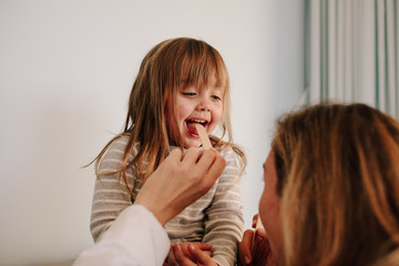 Doctor checking little girl's throat