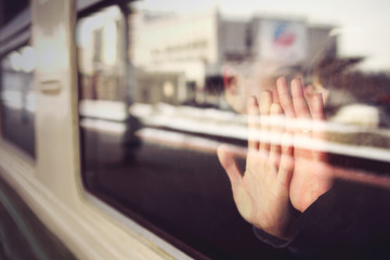 Two hands, male and female on the train window. The couple is sitting on the train, touching the glass with their hands. Love and romance in travel. selective sharpness