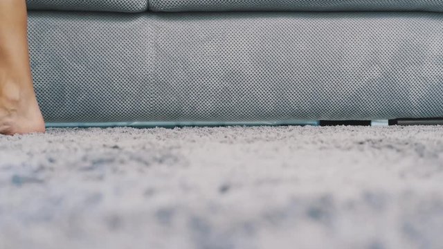 Women's legs are walking on a gray carpet that is on the floor. Fluffy carpet from above. Modern style.