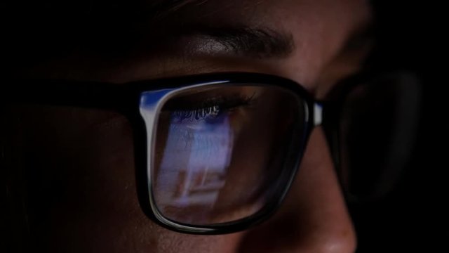 Woman With Glasses Scrolls Through Social Media At Night