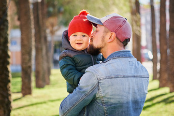 Portrait of a happy young father walking with his little son