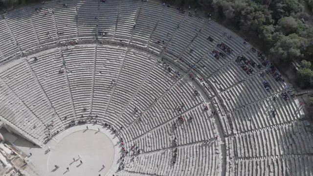 Panning from left to right and above the ancient theater of Epidavros in Greece. Clear sky, sunny weather, flat colour profile.