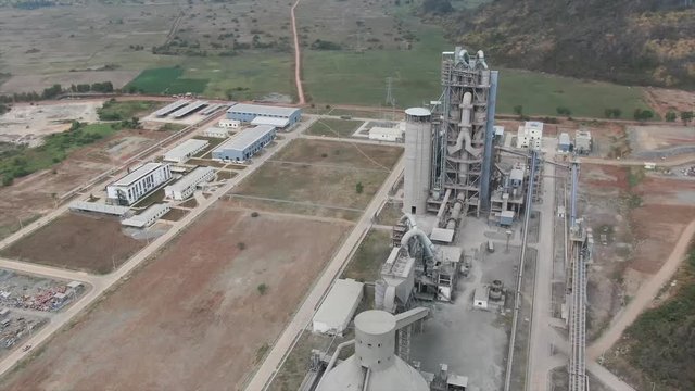 Aerial view flying over large concrete manufacturing plant in the mountains of rural Asia. As development increases in the ASEAN region, construction has increased dramatically.