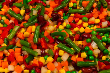 Sliced vegetables, corn, beans, peas, carrots, sweet peppers background.